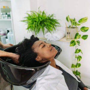 Photo of a hairdresser, washing hair to a customer with an Afro hair
